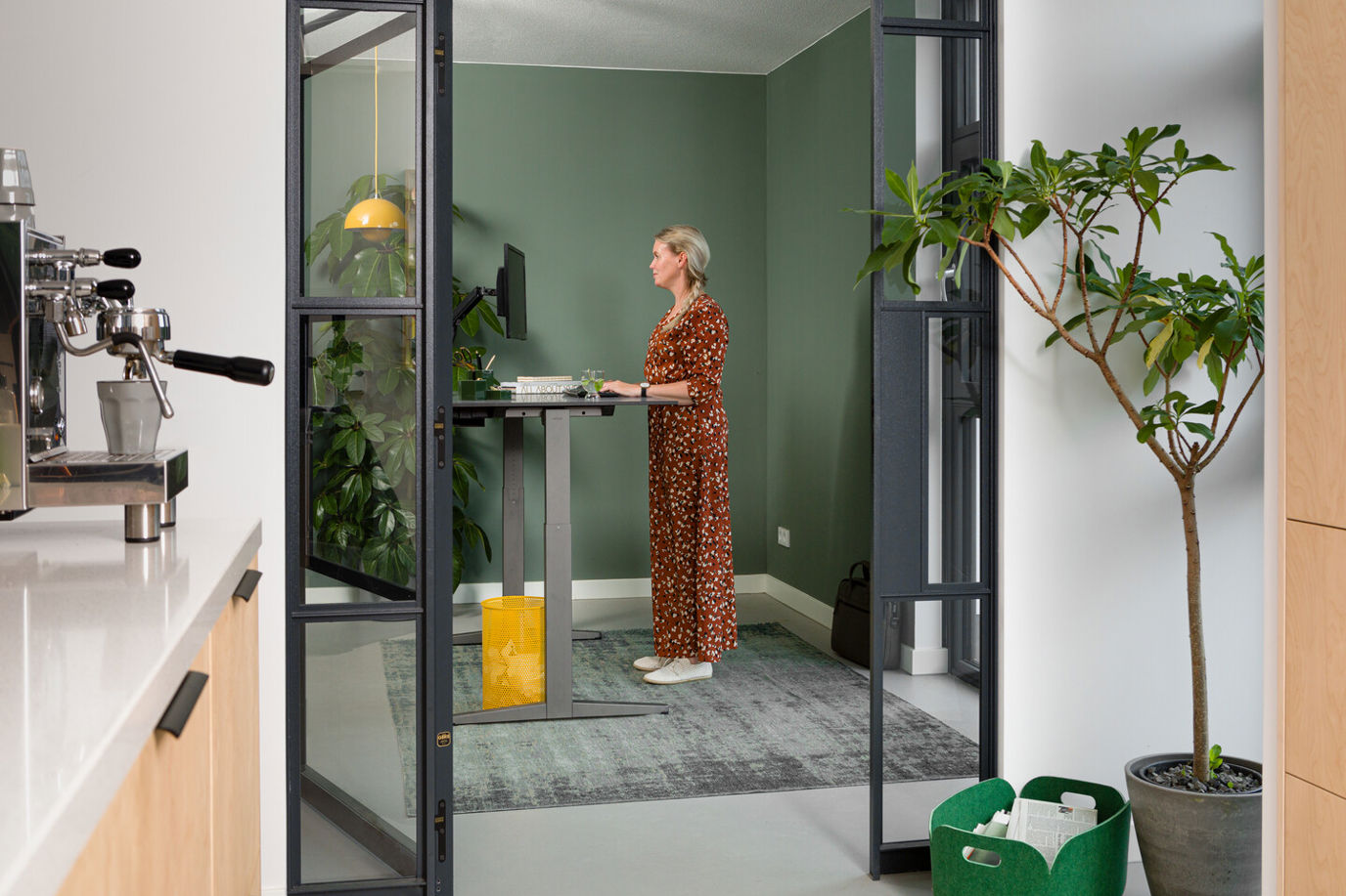 Landscapexl Royal Ahrend Balance Workstation In Grey With Charcoal Tabletop In Standing Position With Female Model Interior View